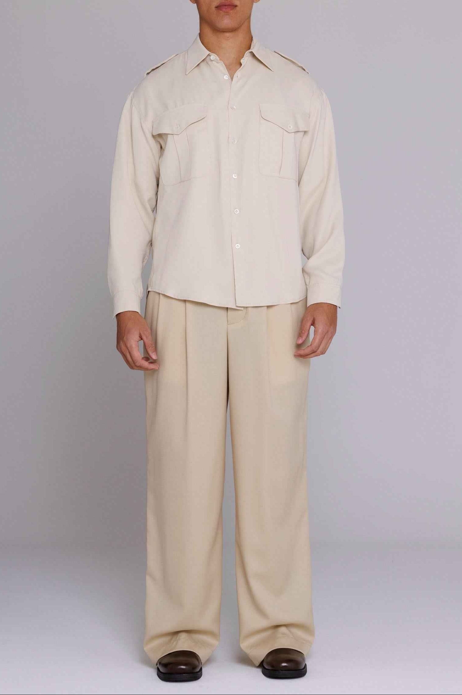 Jones Safari Shirt in Natural Satin with spread collar, chest pockets, and shoulder epaulets, worn by male model in medium fit.