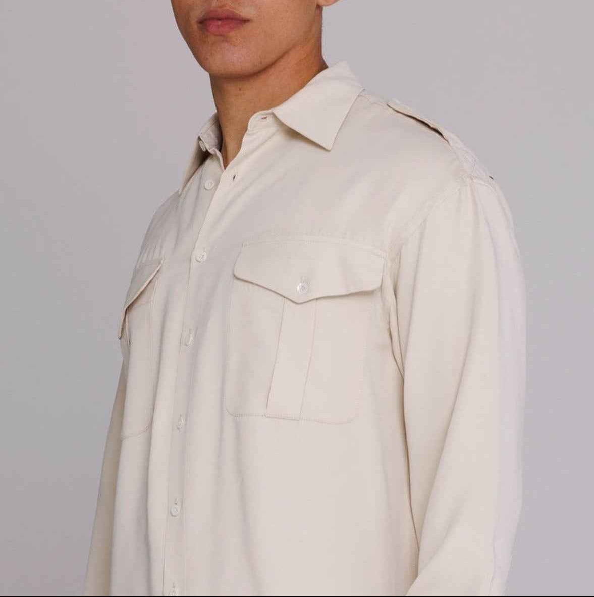 Jones Safari Shirt in Natural Satin with spread collar, chest pockets, and shoulder epaulets, worn by model in medium size.