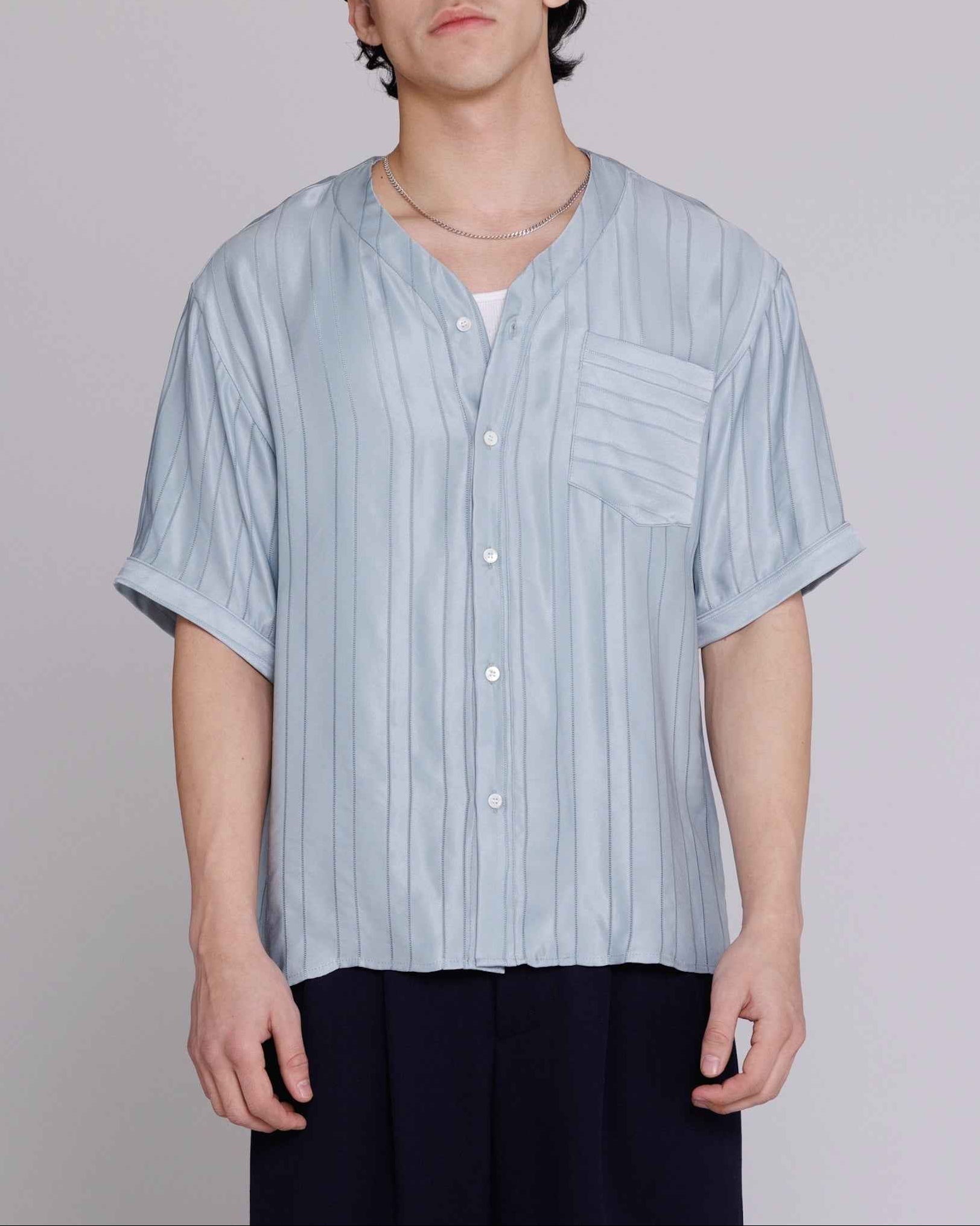 Valenzuela baseball collar shirt in blue satin stripe cupro blend georgette, relaxed fit, worn by model in medium, front chest pocket visible.