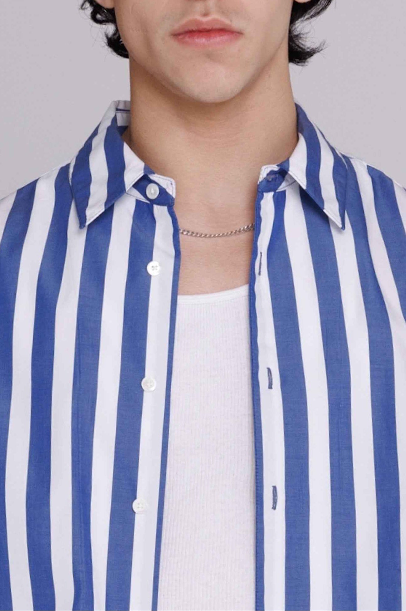Flowers" button-up shirt in blue and white bar stripes on model, shown in relaxed fit cotton poplin with mother of pearl buttons.