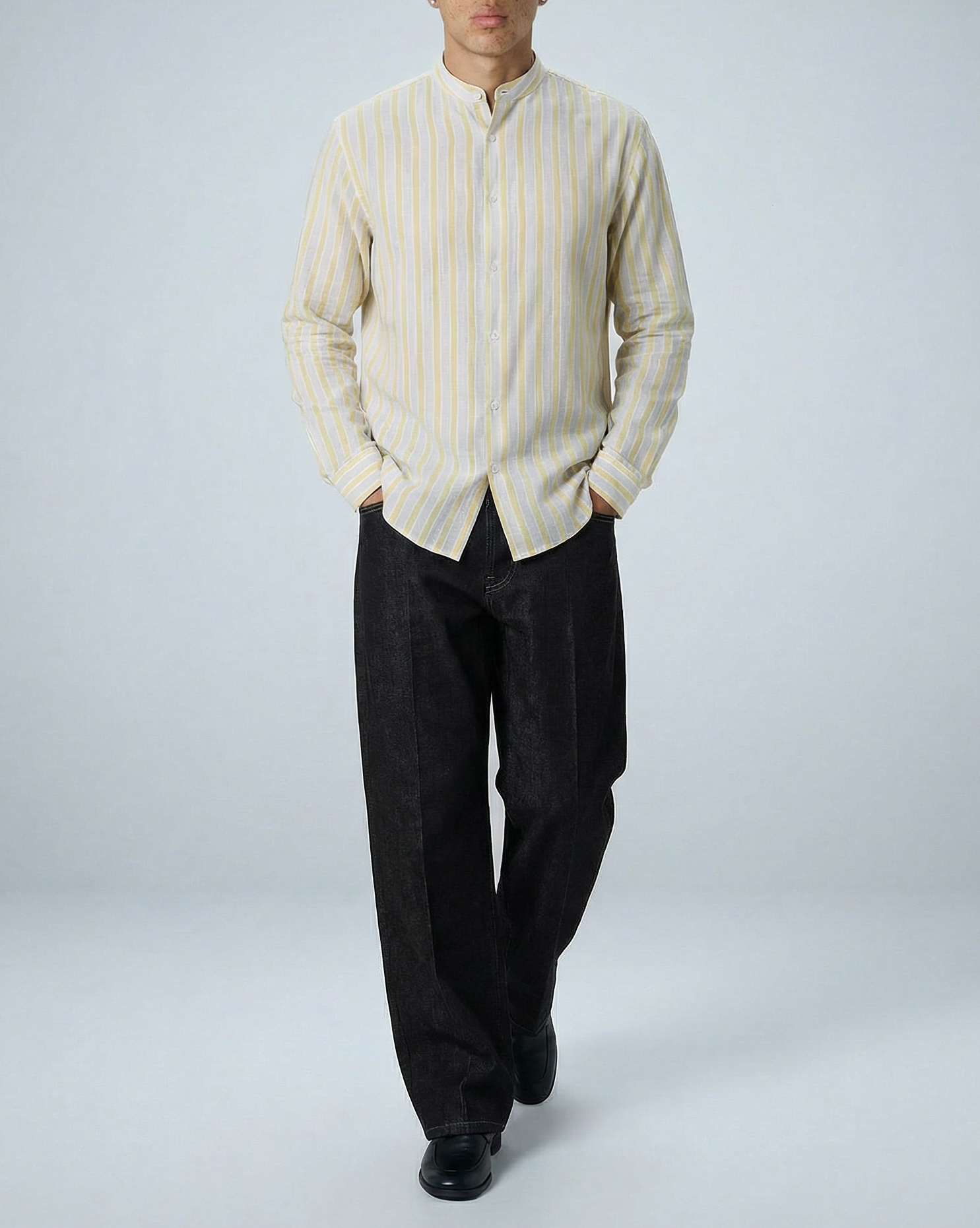 Liam band collar shirt in cream and yellow stripe, relaxed fit, worn untucked by model in three-quarter view showing textured slub cotton fabric.