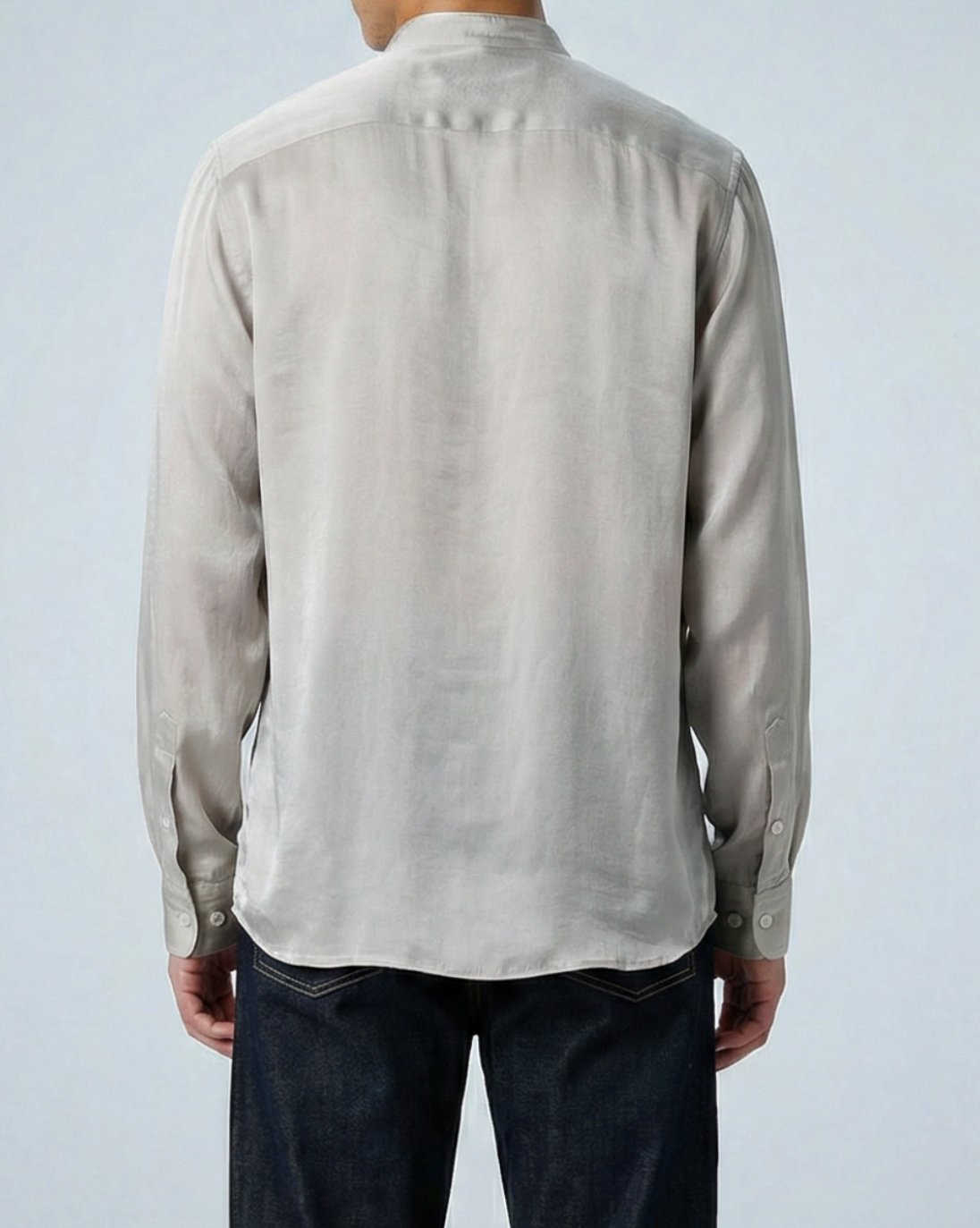 Liam band collar shirt in oyster taupe cupro twill, worn untucked, model facing backward with arms at sides in studio setting.