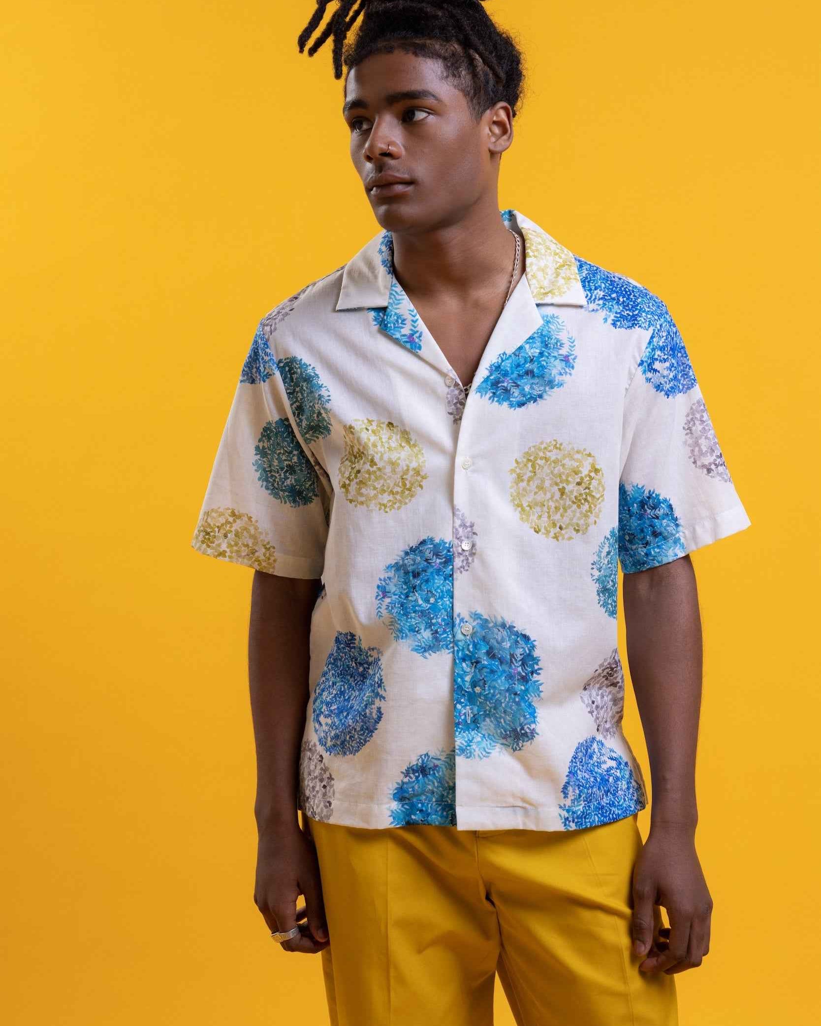 Arnaz Resort Shirt in blue and gold watercolor leaves print, cropped fit, shown on model from chest up against neutral background.