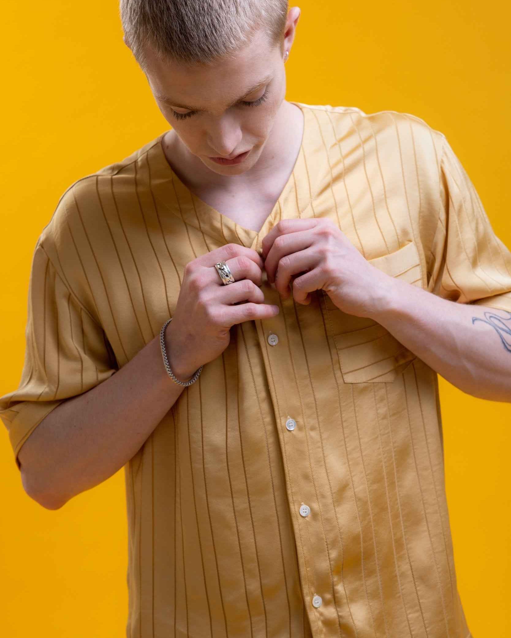 Valenzuela baseball collar shirt in gold satin stripe cupro blend georgette, relaxed fit, shown on model in medium.