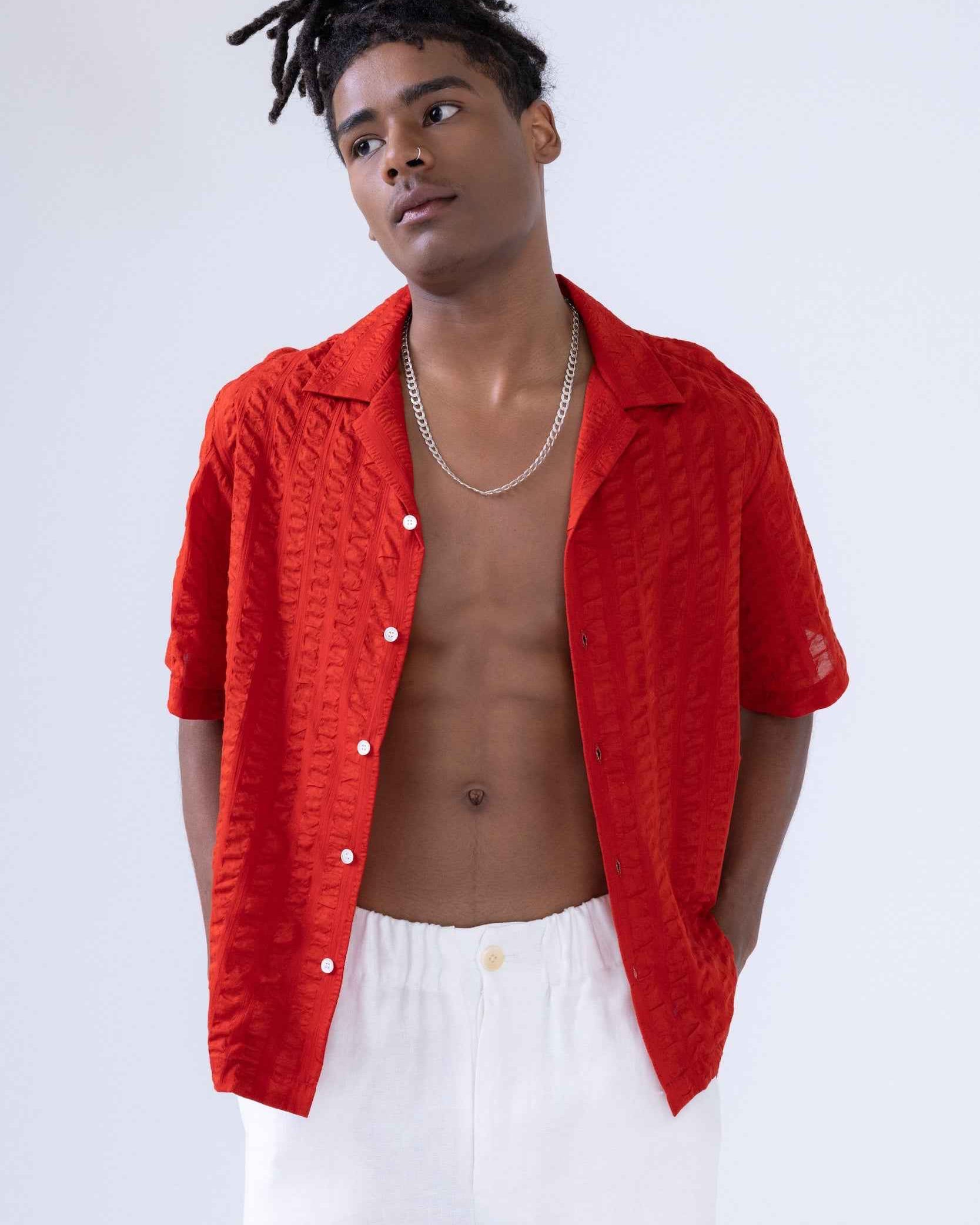 Arnaz Resort Shirt in cherry red seersucker with wide textured stripes, shown on model from chest up, displaying cropped wide fit and side seam openings.