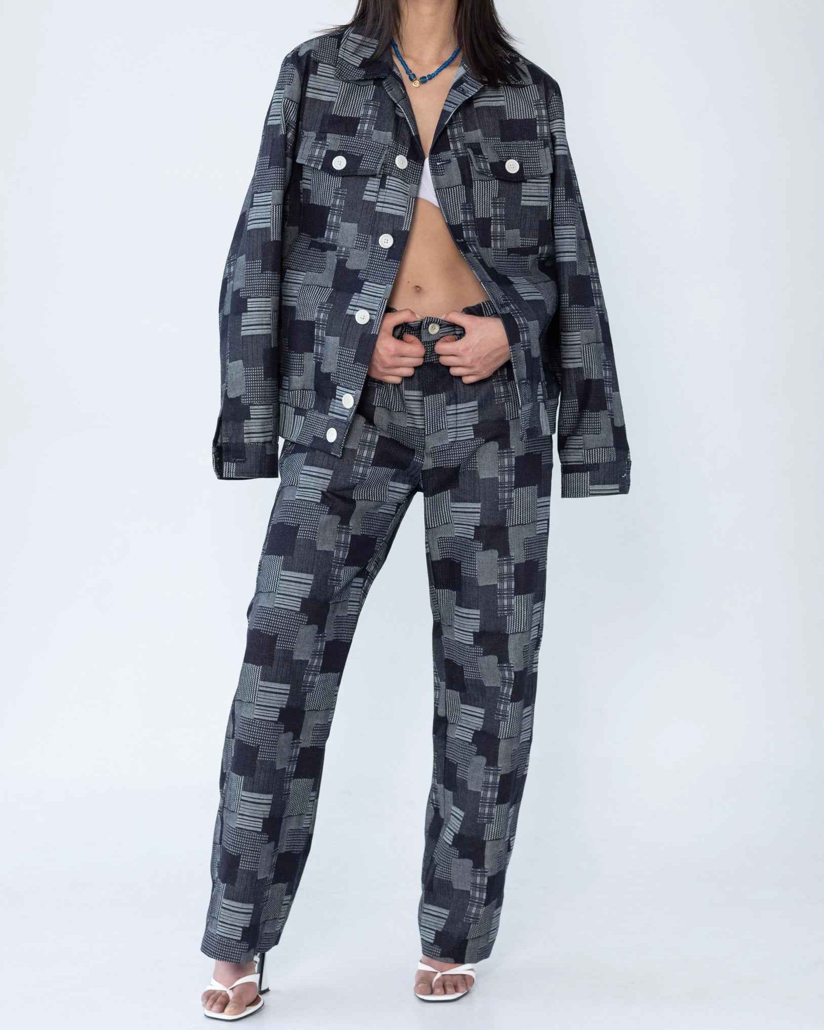 Dean" jacket in dark denim patchwork jacquard with relaxed boxy fit, shown on model displaying textured Japanese woven fabric with mixed weave patterns.