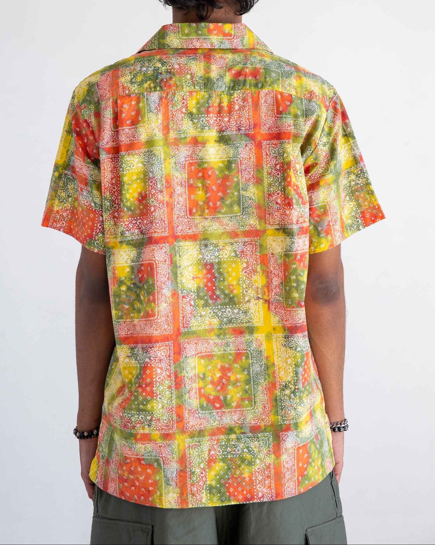Desi short sleeve resort shirt in red batik bandana print, Cuban collar, organic cotton poplin, relaxed fit with side slits.
