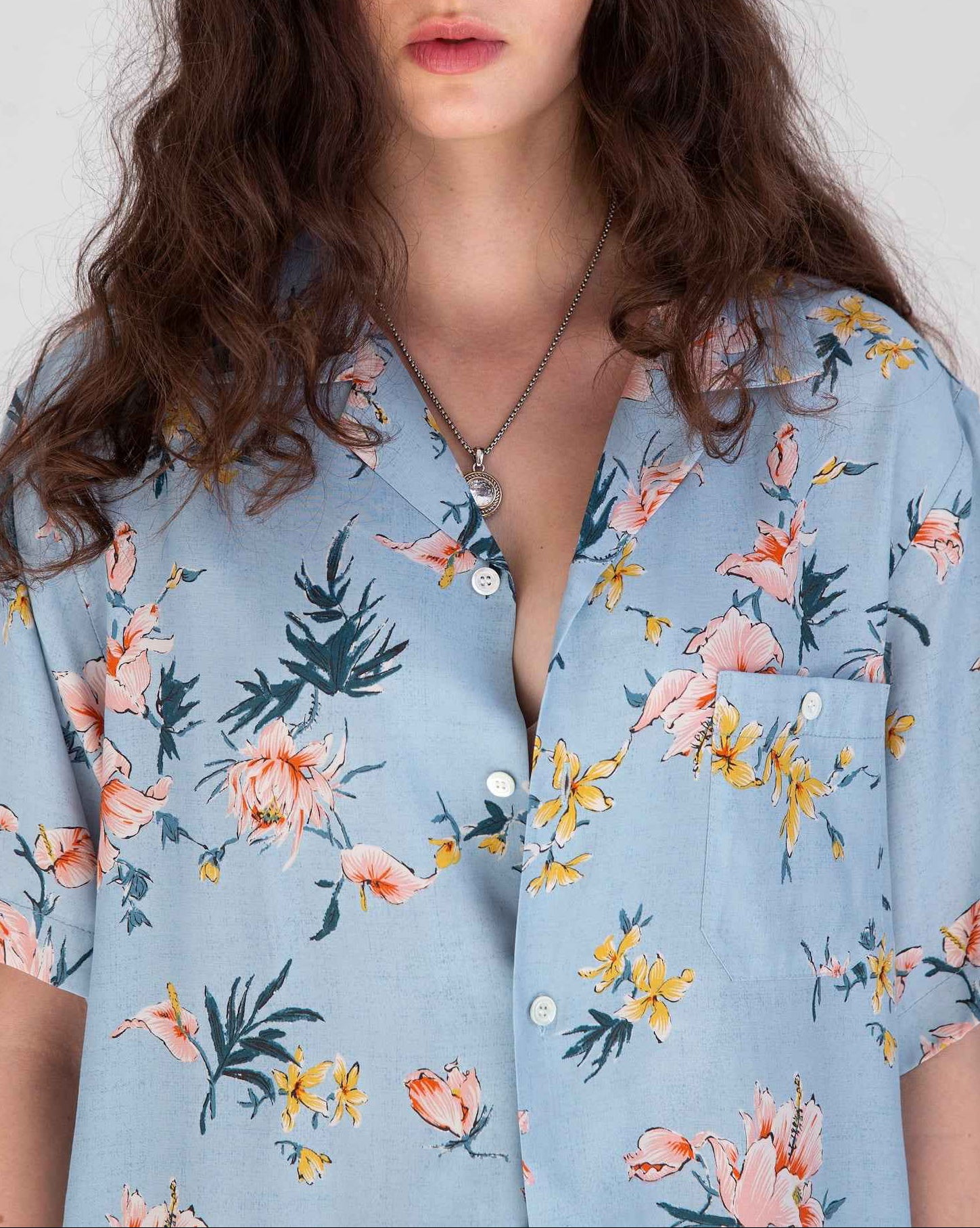 Desi short sleeve resort shirt in light blue Ukiyoe hibiscus print, rayon poplin fabric, camp collar, displayed on model.