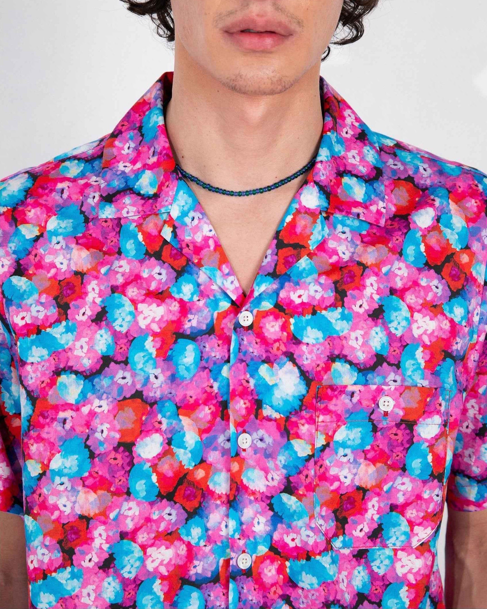Desi camp collar shirt in red floral Dream Pop print, worn by model in relaxed fit with side slits, cotton and Tencel twill fabric.