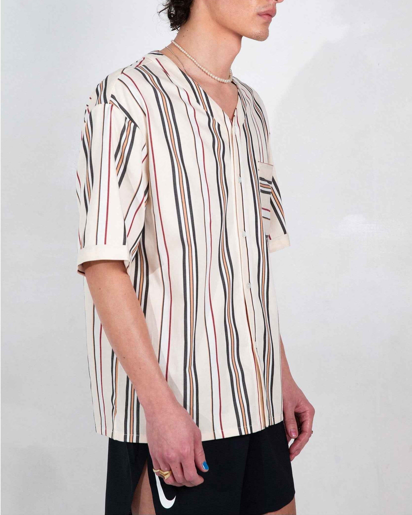Valenzuela cream striped baseball shirt on model, relaxed boxy fit with side slits and chest pocket visible