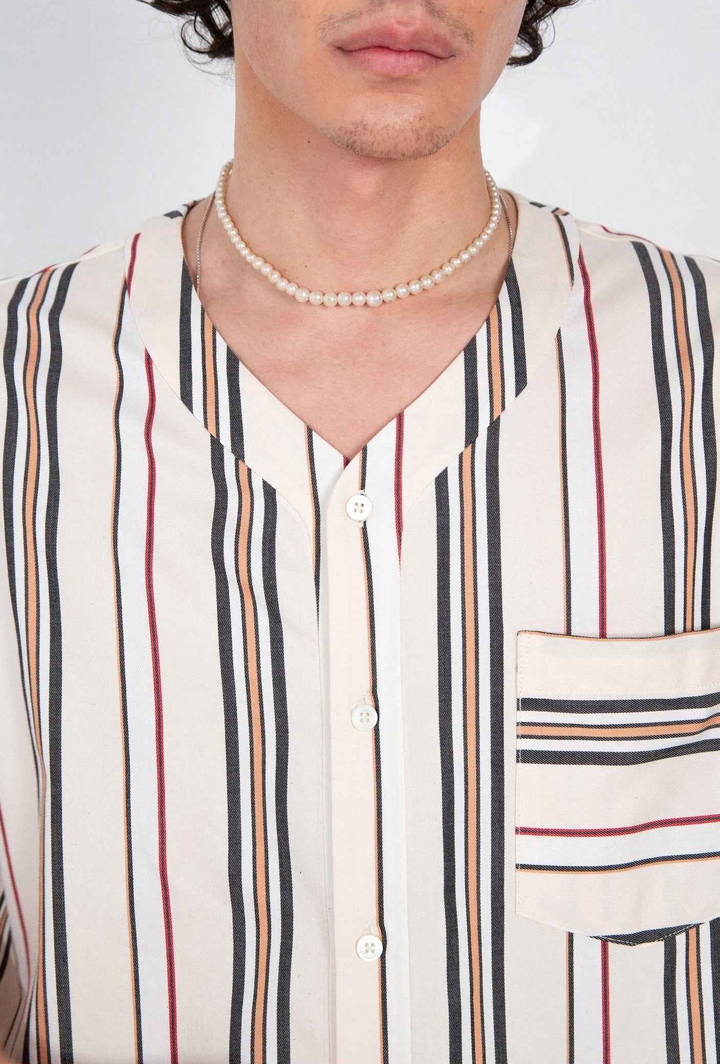 Valenzuela cream striped baseball shirt on model, relaxed boxy fit with side slits and chest pocket detail visible