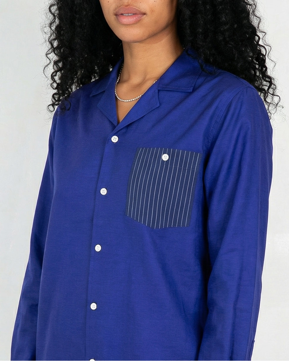 Arenas convertible-collar shirt in royal blue and white stripe cotton cupro linen, worn by woman with long curly hair and silver jewelry, relaxed contemporary fit.