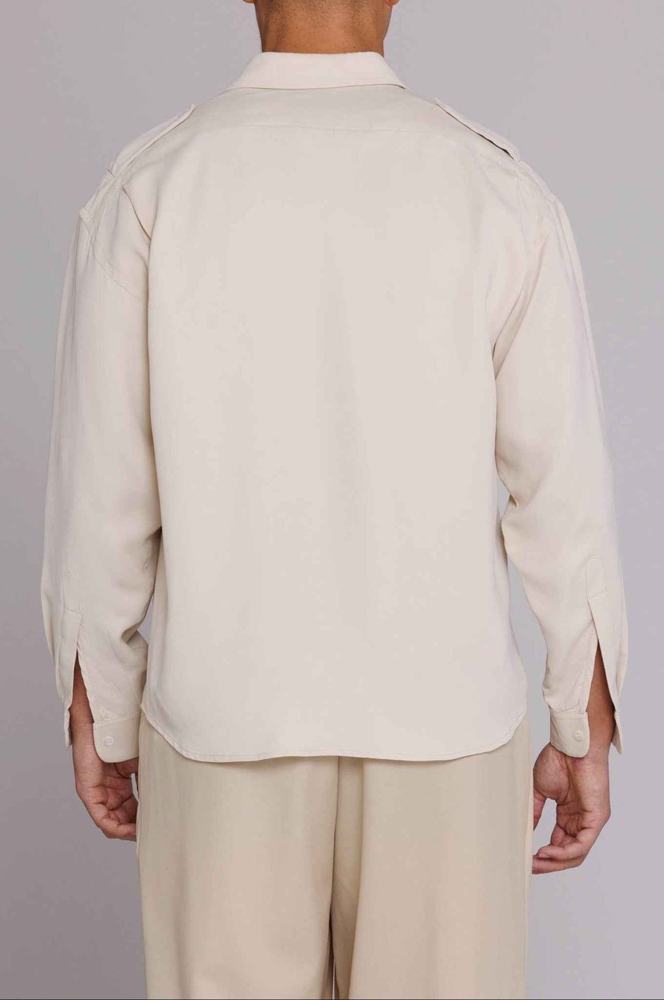 Jones" Safari Shirt in Natural Satin with matte cupro fabric, spread collar, dual chest pockets, and shoulder epaulets on model.