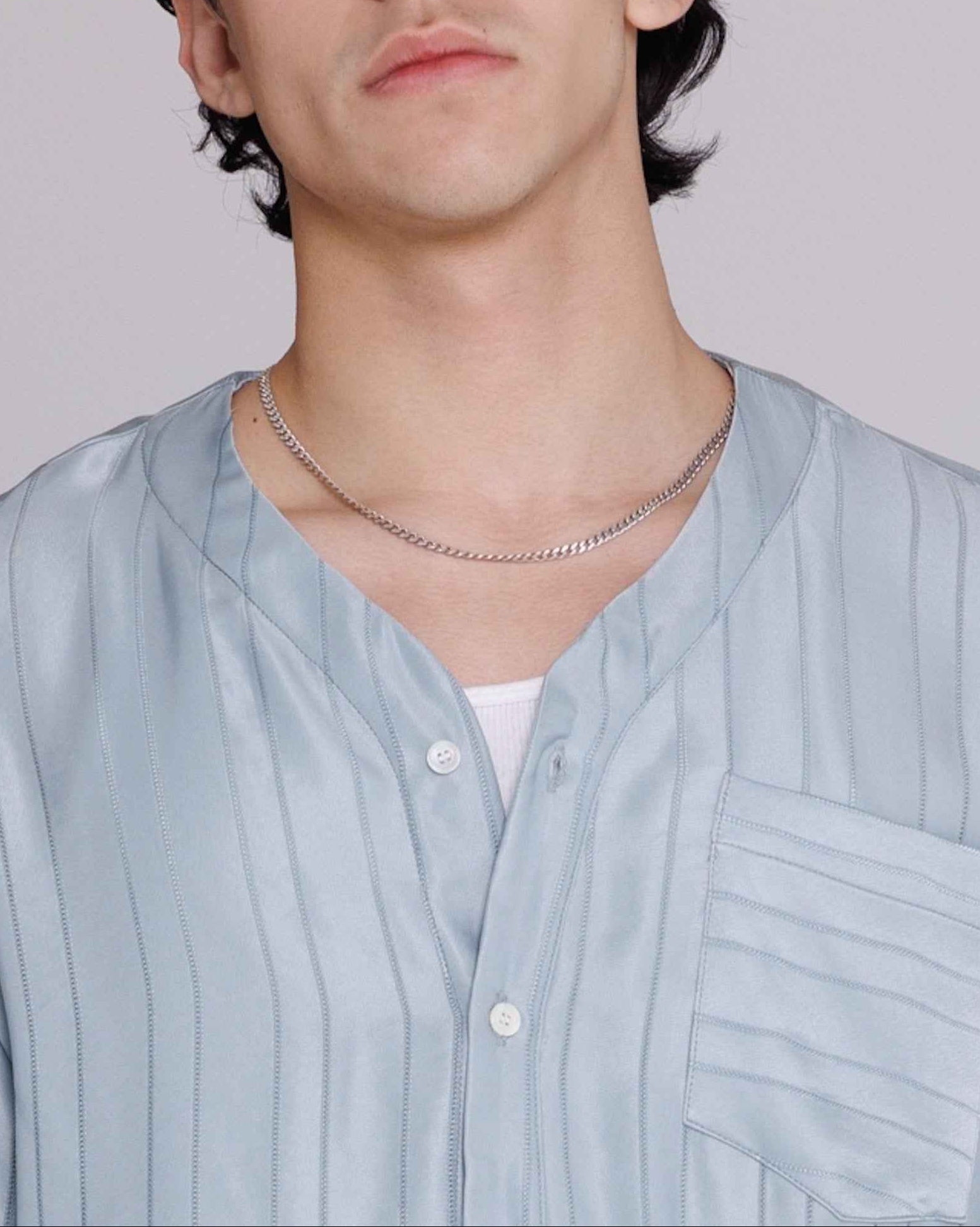 Valenzuela baseball collar shirt in blue satin stripe cupro georgette, relaxed fit, modeled on man against white background.