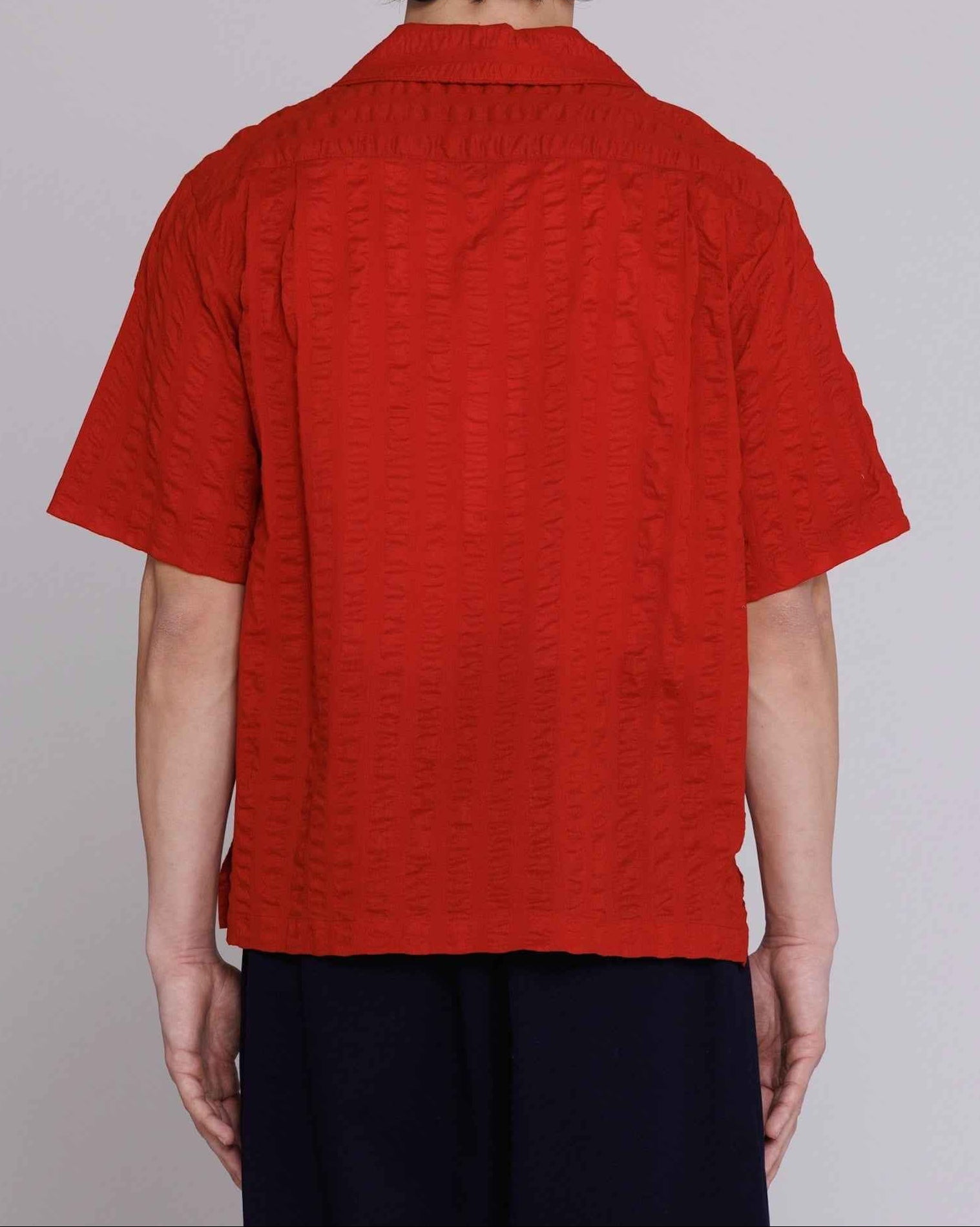 Arnaz Resort Shirt in cherry red seersucker with wide textured stripe, cropped fit, worn by model in three-quarter view pose.