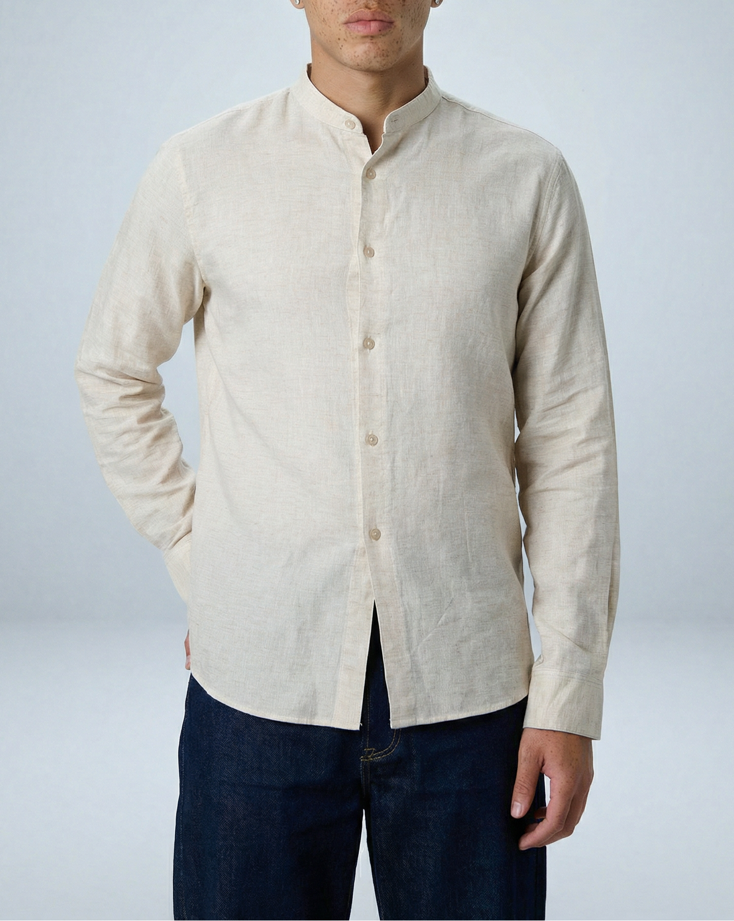 Model wearing Liam band collar shirt in vintage cream linen cotton, relaxed fit, hand in back pocket, facing forward close-up shot.