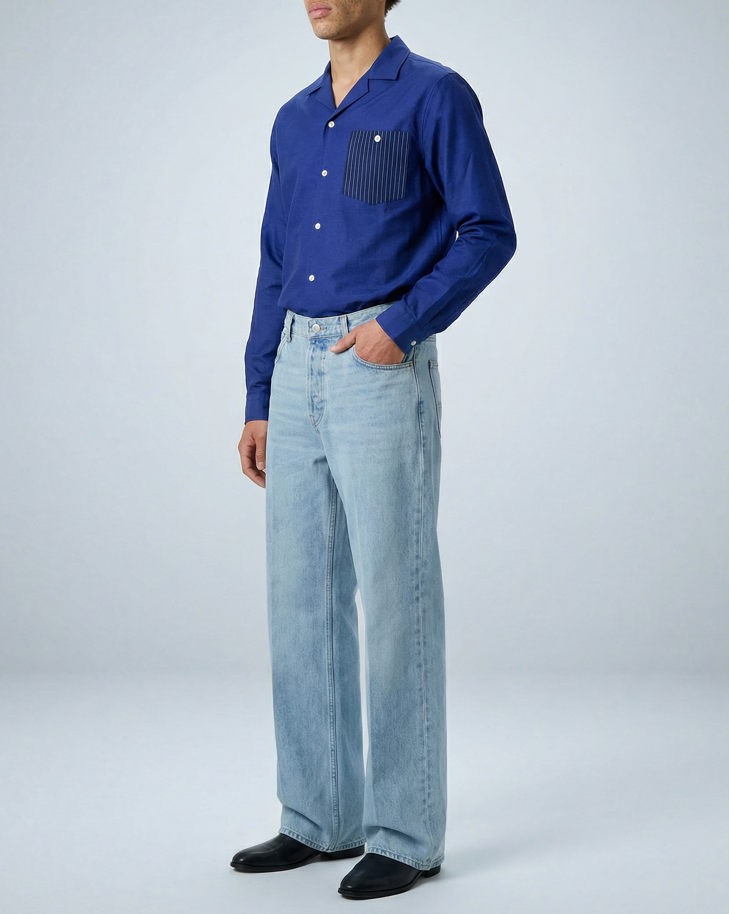 Model wearing Arenas convertible-collar shirt in royal blue and white stripe, tucked in, shown full-length at side angle with hand in pocket.