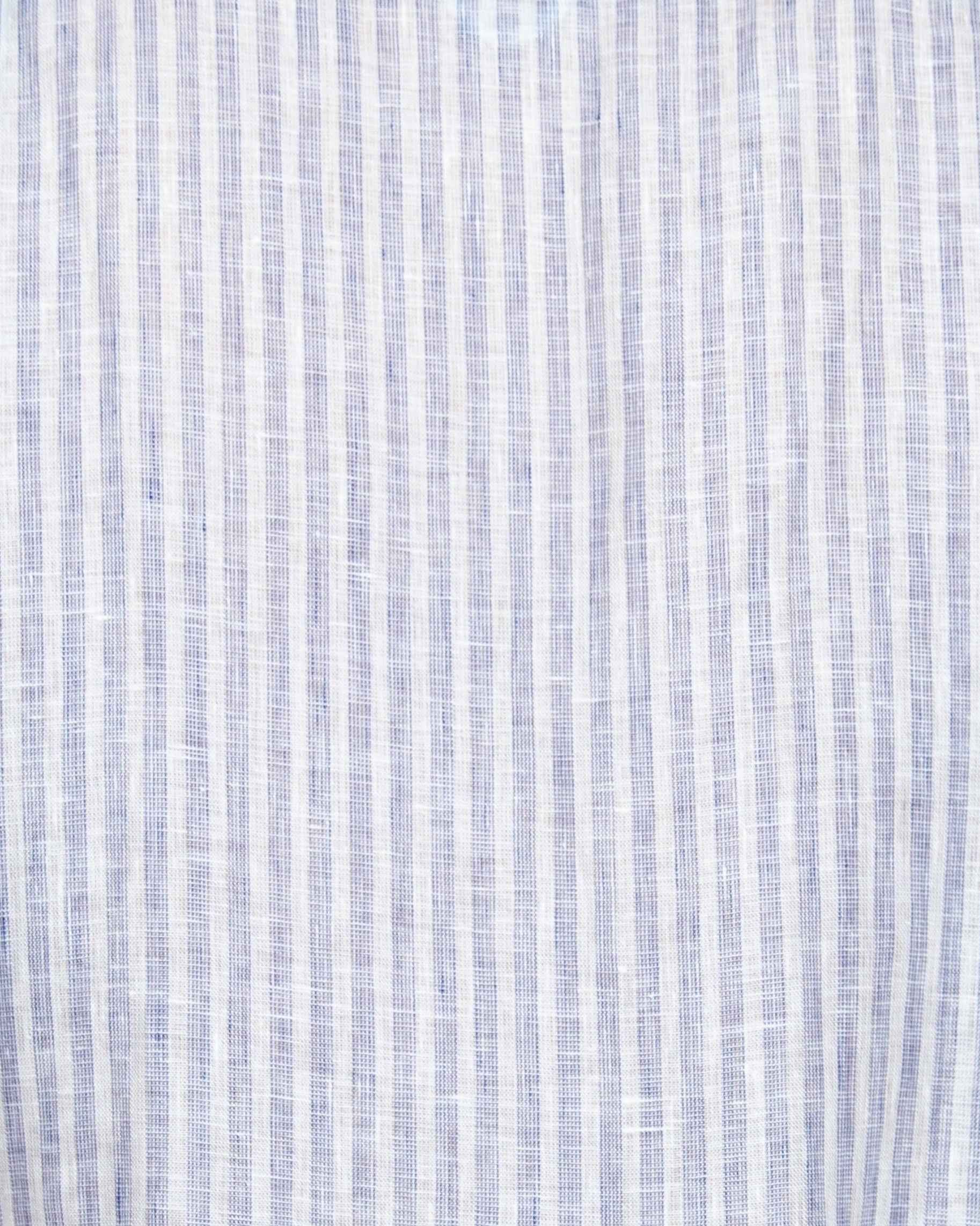 Liam band collar shirt in white and blue linen stripe, relaxed fit, shown on model with button cuffs and natural shoulder seam placement.
