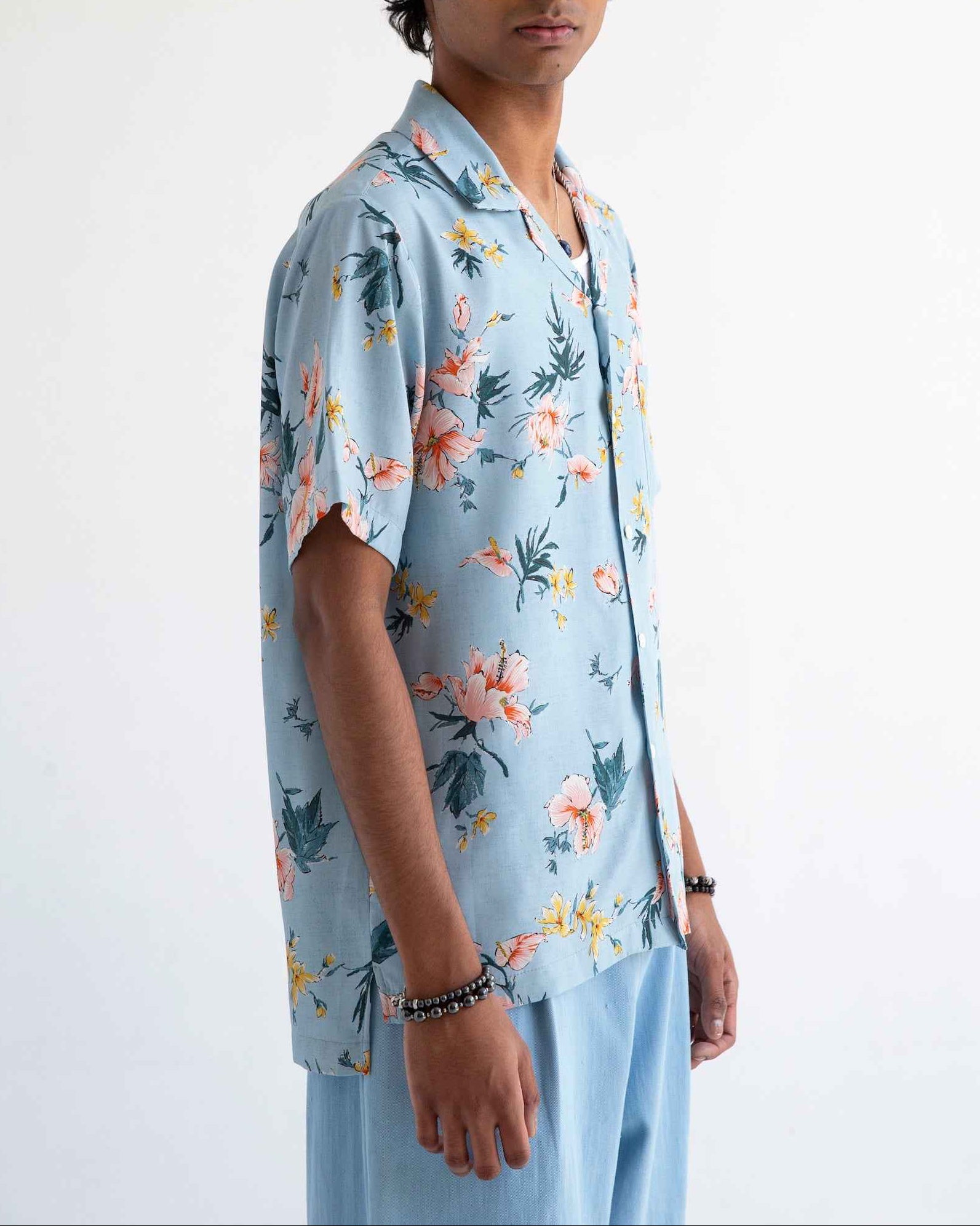 Desi short sleeve resort shirt in light blue Ukiyoe hibiscus print, rayon poplin with camp collar, displayed on model.