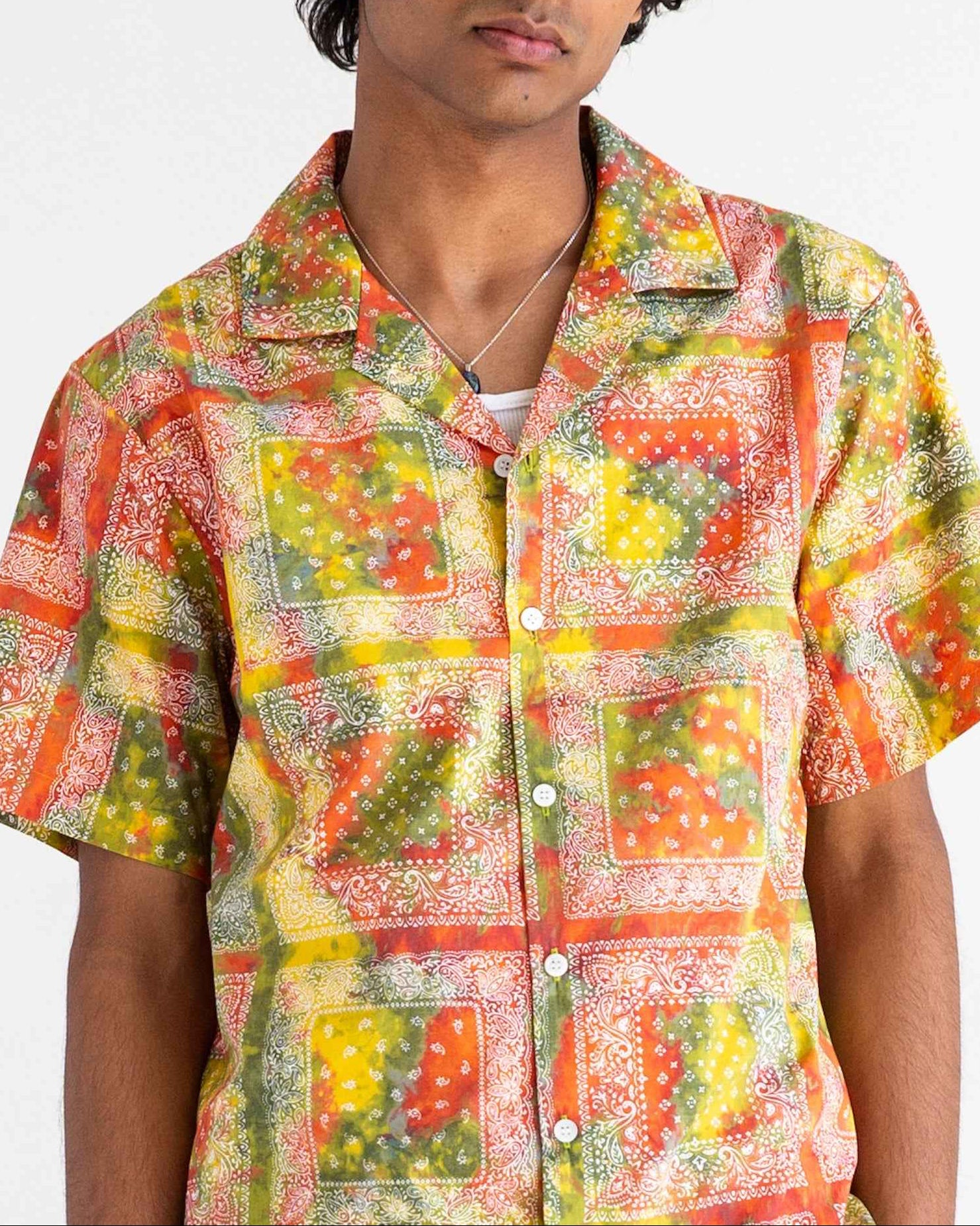 Desi short sleeve resort shirt in red batik bandana print, organic cotton poplin, Cuban collar with side slits, relaxed summer fit.