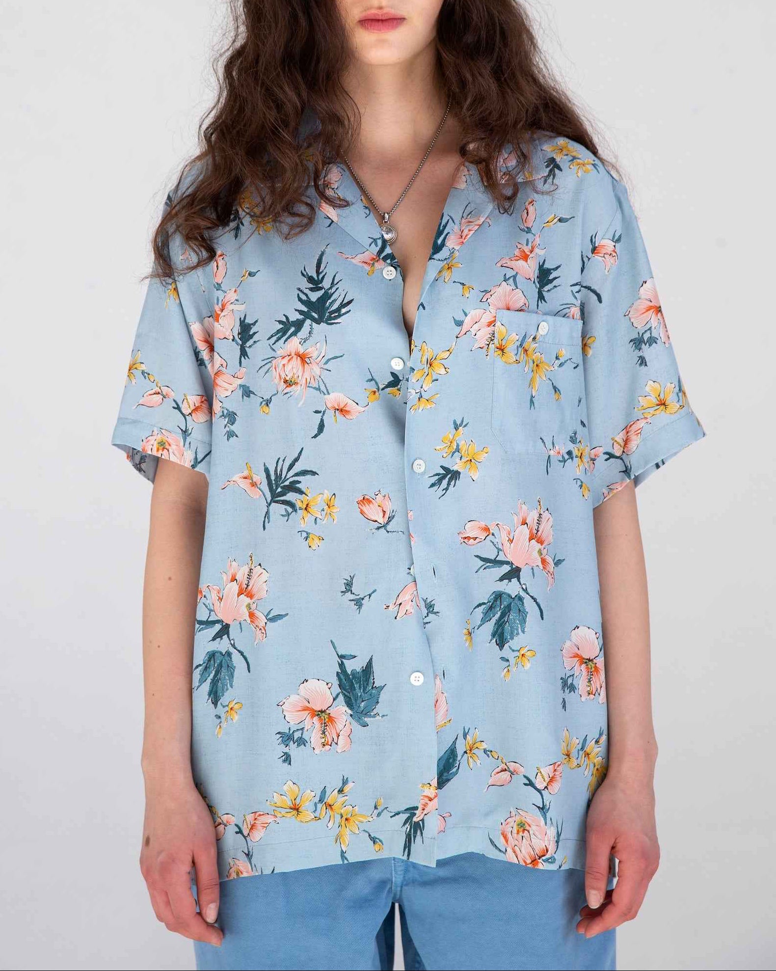 Desi short sleeve resort shirt in light blue Ukiyoe hibiscus print, rayon poplin fabric, camp collar, shown on model.