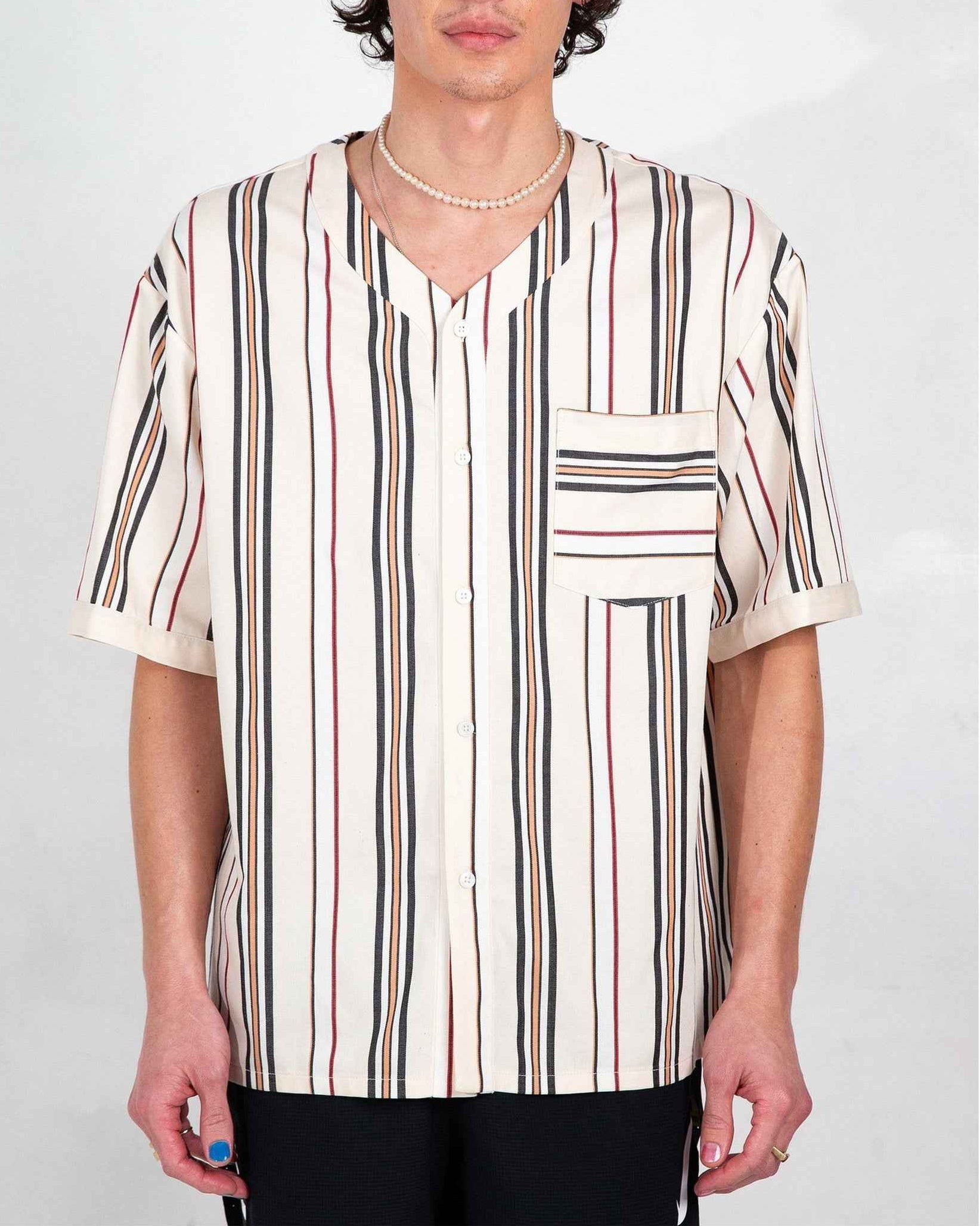 Cream and white striped baseball collar short sleeve shirt with relaxed boxy fit, displayed on male model in three-quarter view.