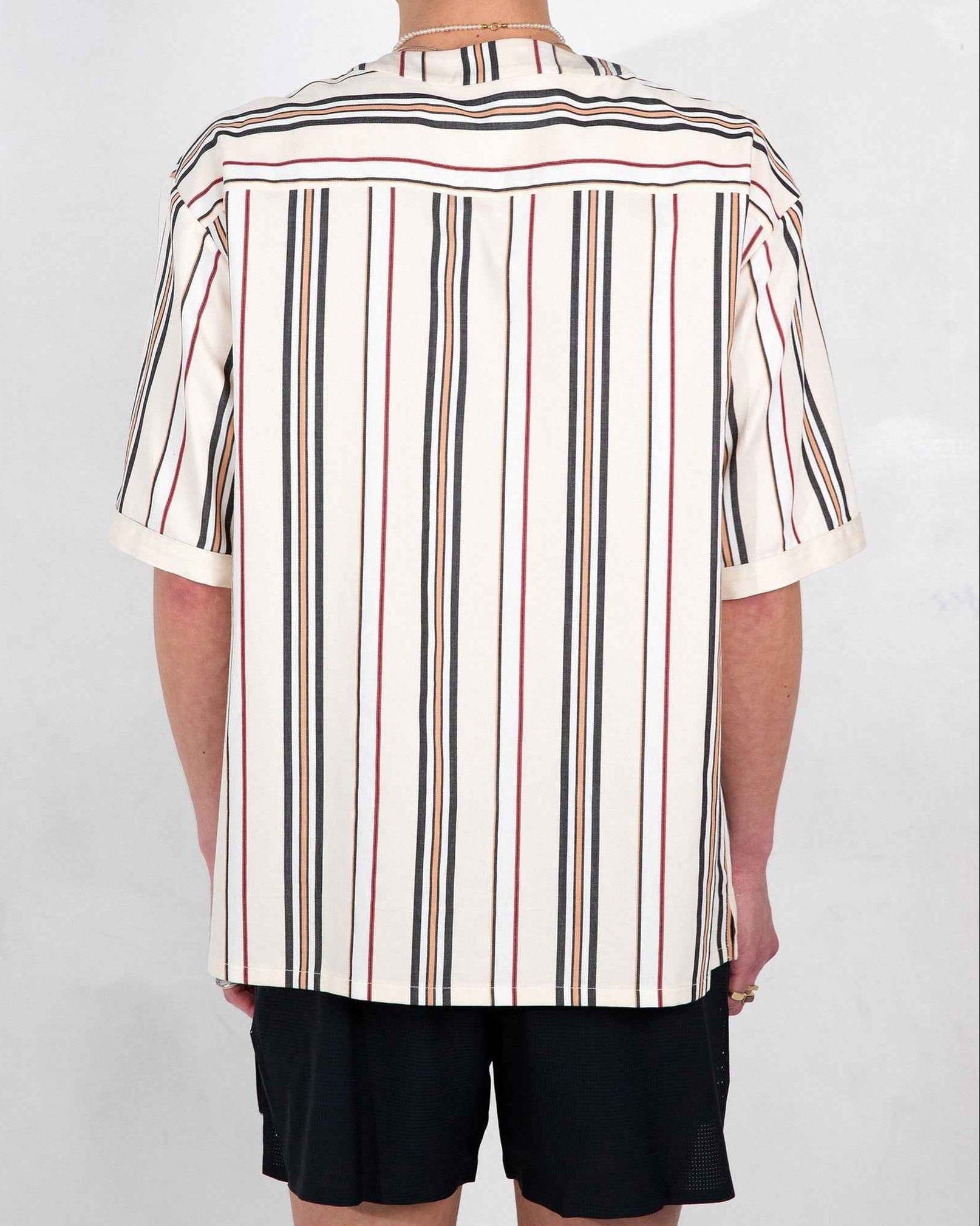 Valenzuela cream stripe baseball shirt with relaxed boxy fit and side slits, worn by model in medium, front view detail.